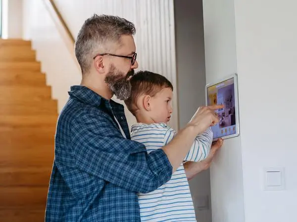 Father and son are using home security system